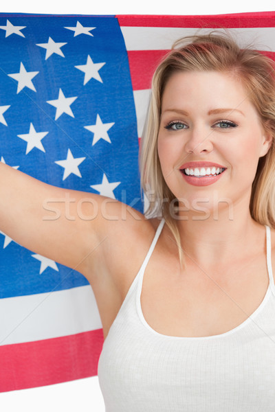 Smiling woman holding the Old Glory flag in a studio Stock photo © wavebreak_media