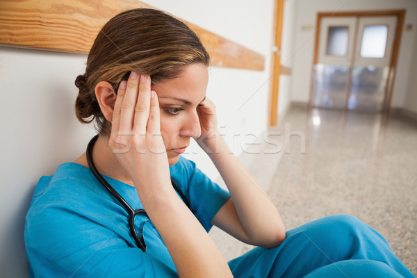 Pielęgniarki posiedzenia piętrze korytarz ręce głowie Zdjęcia stock © wavebreak_media