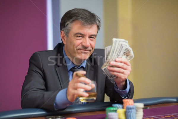 Hombre dinero sonriendo ruleta mesa Foto stock © wavebreak_media