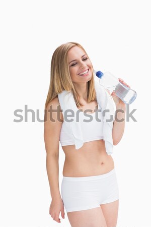 Happy young woman with towel around neck holding water bottle Stock photo © wavebreak_media