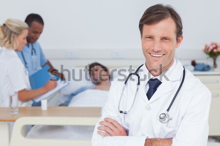 Doctor looking at phone with his team of nurses Stock photo © wavebreak_media