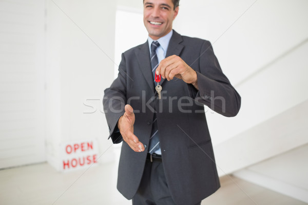 Businessman offering a handshake while holding up keys Stock photo © wavebreak_media