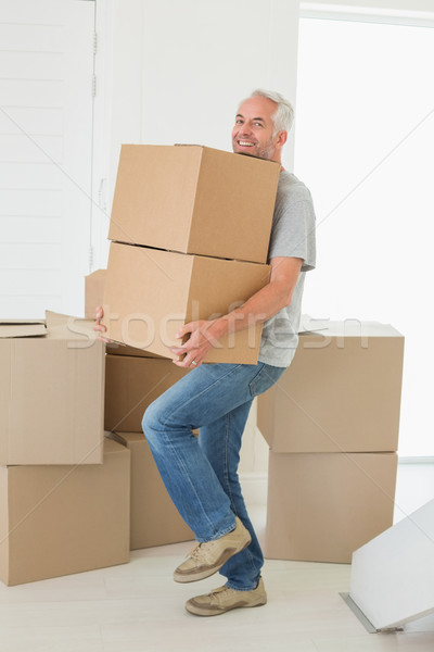 Smiling man carrying cardboard moving boxes Stock photo © wavebreak_media