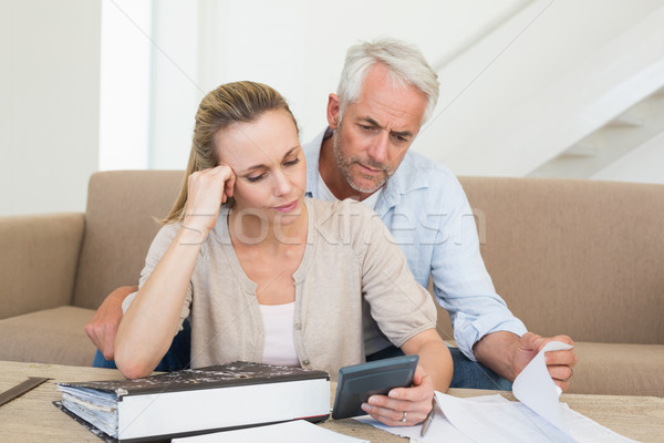 Serious couple calculating their bills at the couch Stock photo © wavebreak_media
