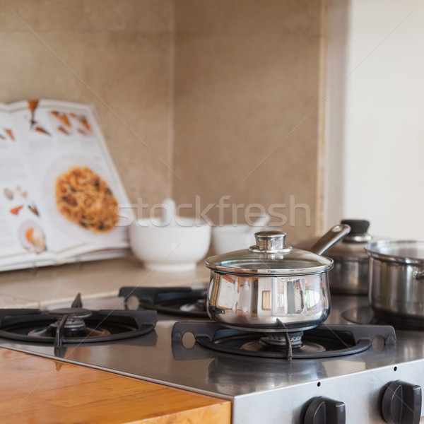 Stove top with saucepan and recipe book Stock photo © wavebreak_media