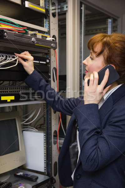 Pretty computer technician talking on phone while fixing server Stock photo © wavebreak_media