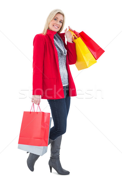 Happy blonde in winter clothes holding shopping bags Stock photo © wavebreak_media