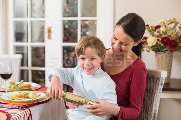 Little boy pulling a christmas cracker with his mother  Stock photo © wavebreak_media