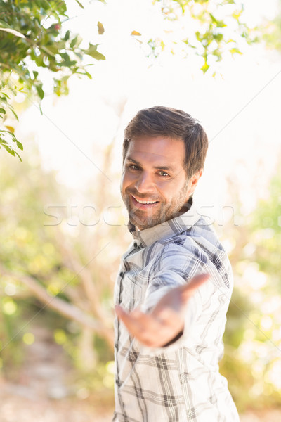 Happy man smiling at camera offering hand Stock photo © wavebreak_media