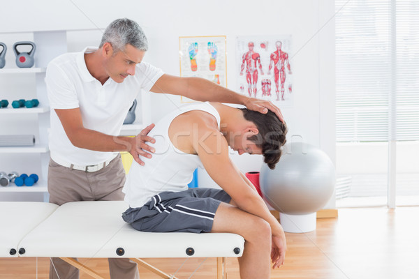 Doctor stretching a young man back Stock photo © wavebreak_media
