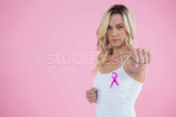 Portrait of young woman with Breast Cancer Awareness ribbon punching Stock photo © wavebreak_media