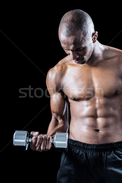 Muscular athlete exercising with dumbbell Stock photo © wavebreak_media