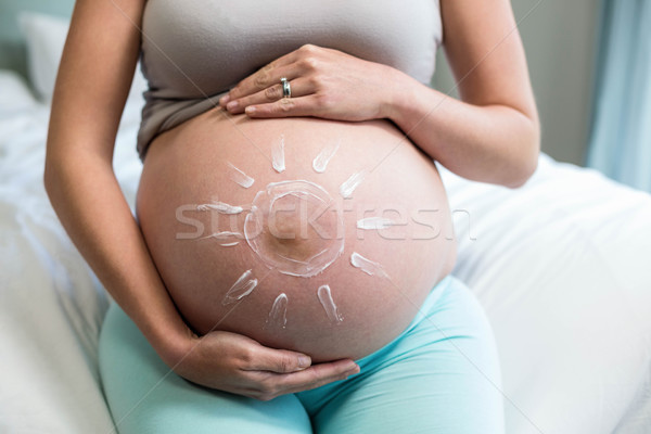 Pregnant woman applying cream on her belly Stock photo © wavebreak_media