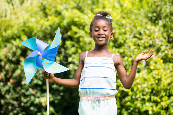 Cute mixed-race girl smiling and holding a windmill Stock photo © wavebreak_media