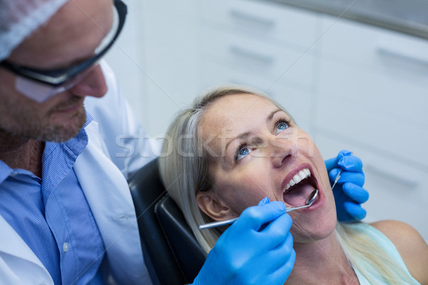 Dentist examining a woman with tools Stock photo © wavebreak_media