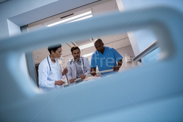 Doctors adjusting iv drip while patient lying on bed Stock photo © wavebreak_media