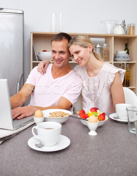 Enamored couple using a laptop while having breakfast  Stock photo © wavebreak_media