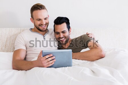 Laughing couple using a laptop in the bedroom Stock photo © wavebreak_media