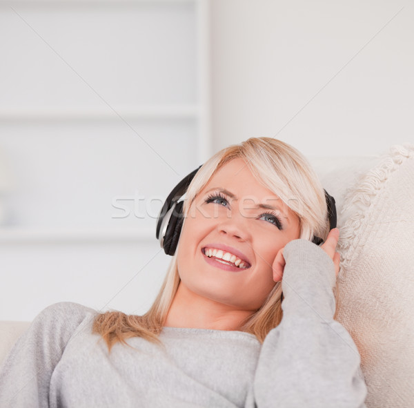 Csinos fiatal szőke nő fejhallgató kanapé Stock fotó © wavebreak_media