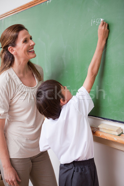 Portrait of a schoolteacher helping a schoolboy doing an addition on a blackboard Stock photo © wavebreak_media