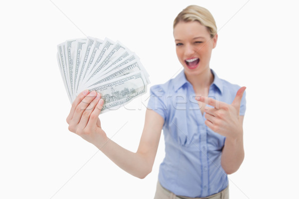 Woman holding money and pointing at it against a white background Stock photo © wavebreak_media