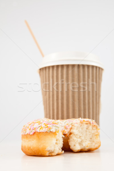 An half eaten multi coloured doughnut and a cup of tea placed together against a white background Stock photo © wavebreak_media