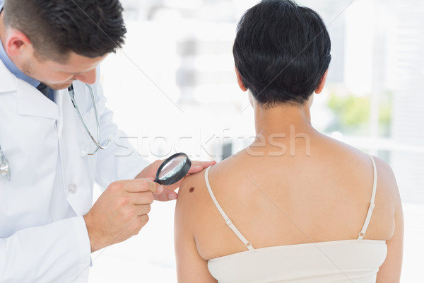 Dermatologue femme loupe clinique bureau [[stock_photo]] © wavebreak_media