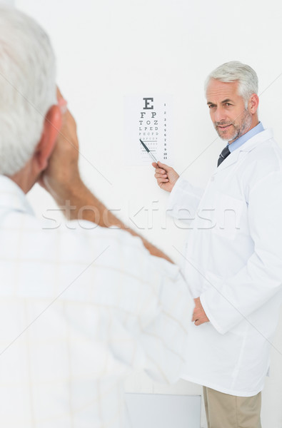 Pediatrician ophthalmologist with senior patient pointing at eye Stock photo © wavebreak_media