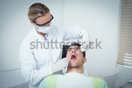 Pediatric dentist examining a patients teeth in the dentists cha Stock photo © wavebreak_media