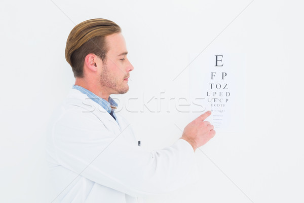 Stock photo: Optician in coat pointing eye test