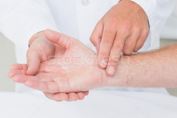 Stock photo: Male doctor checking patients pulse