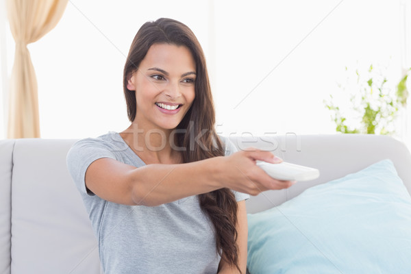 Happy young woman changing channels Stock photo © wavebreak_media
