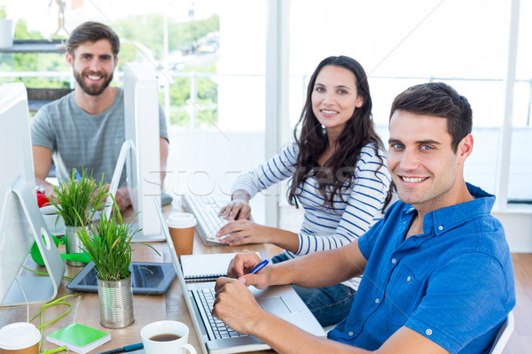 Stock photo: Creative colleagues using laptop in meeting