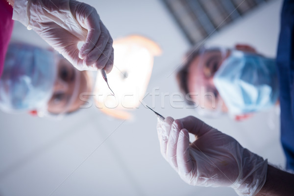 Dentist and assistant leaning over patient with tools Stock photo © wavebreak_media