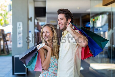 Smiling couple with shopping bags taking selfies with selfiestic Stock photo © wavebreak_media