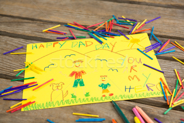 Stock photo: High angle view of fathers day greeting card amidst crayons on table