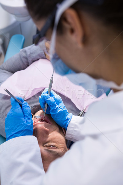 Stock photo: Doctor giving dental treatment to man at clinic