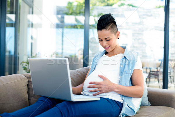 Pregnant woman relaxing on sofa with her laptop Stock photo © wavebreak_media