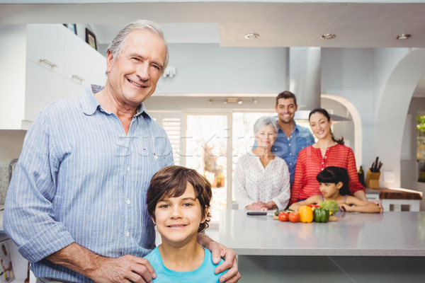 Boy with grandfather while family by kitchen table in background Stock photo © wavebreak_media