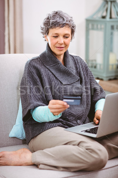Olgun kadın bakıyor kredi kartı dizüstü bilgisayar kullanıyorsanız ev bilgisayar Stok fotoğraf © wavebreak_media
