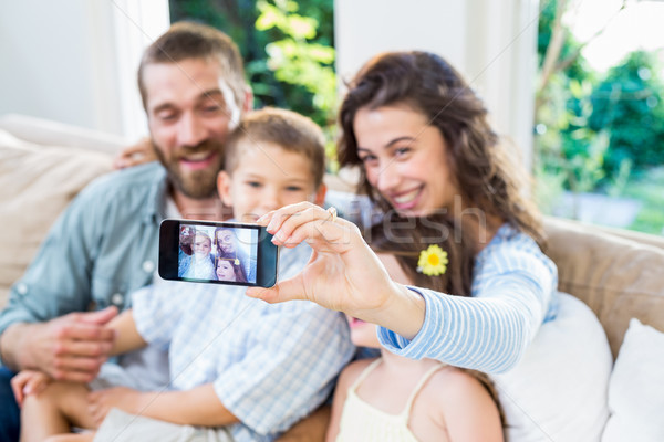 счастливая семья мобильного телефона женщину человека домой Сток-фото © wavebreak_media