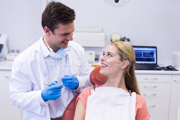Dentist interacting with female patient while examining Stock photo © wavebreak_media