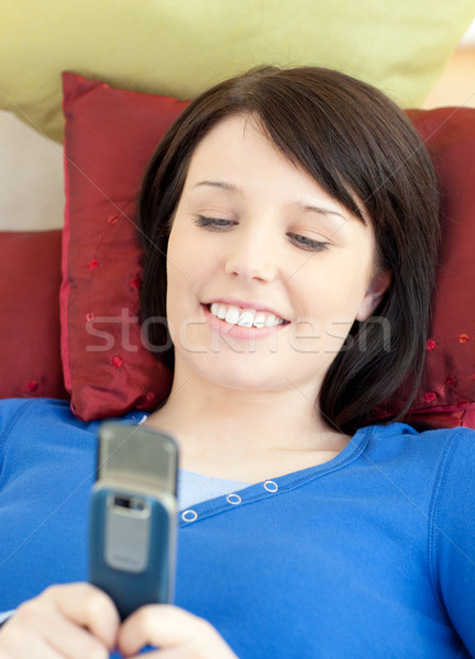 Csinos tinilány küldés szöveg kanapé nappali Stock fotó © wavebreak_media