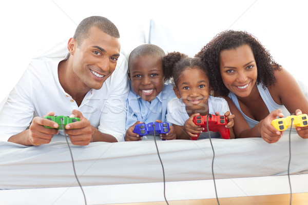 Animated family playing video game lying down on bed Stock photo © wavebreak_media