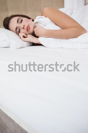 Tired woman switching off her alarm clockin her bedroom Stock photo © wavebreak_media