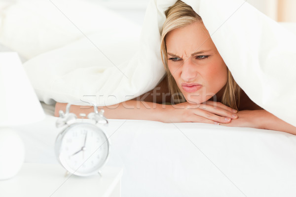 Disgruntled blonde woman waking up in her bedroom Stock photo © wavebreak_media