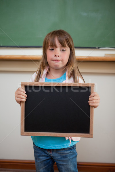 Portrait of a little girl holding a school slate in a classroom Stock photo © wavebreak_media