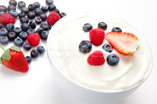 Stock photo: Bowl of cream with berries against a white background