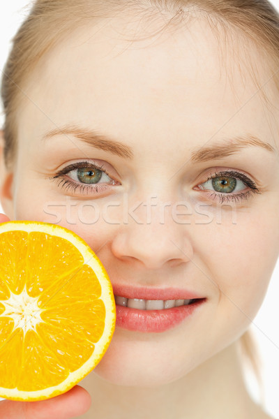 Close up of a woman placing an orange on her lips Stock photo © wavebreak_media