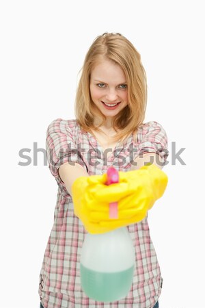 Smiling woman holding a spray bottle against white background Stock photo © wavebreak_media